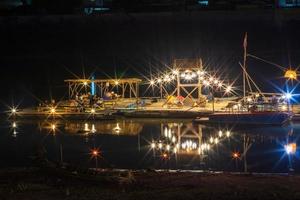 restaurant bamboevlot dat 's nachts de rivier drijft met lichten. foto