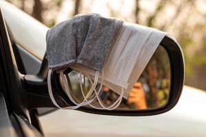 hygiënische maskers op de zijspiegel van de auto. foto