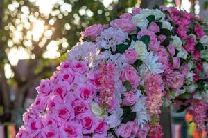 veel kunstmatige boeketten van roze bloemen met bokeh-verlichting. foto