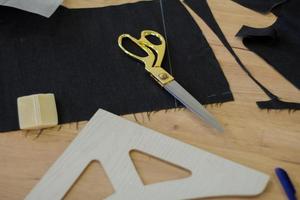 naaister aan het werk aan tafel, kleermaker vrouw werk in studio met kleding foto