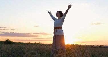 vrouw die qigong beoefent in zomervelden met prachtige zonsondergang op de achtergrond foto