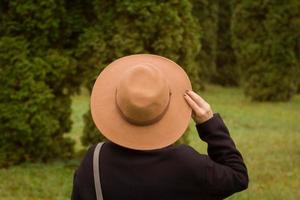 vrouw met hoed die alleen in het prachtige herfstpark loopt foto