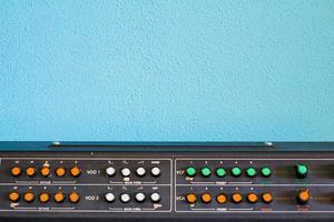 oude synthesizer met kleurrijke schakelaars op blauwe achtergrond foto