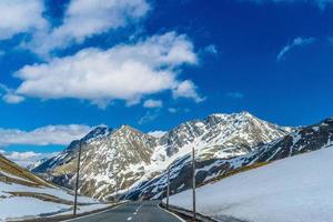 weg tussen besneeuwde alpen bergen, fluelapass, davos, graubuende foto