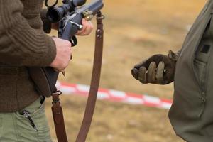 mannelijke training met pompactie shotgun buiten in het veld. foto