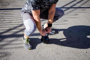 jonge, bebaarde mannelijke atleet training in industriële zone in zonnige dag, kettlebells oefeningen buitenshuis, stedelijke achtergrond foto