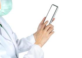 Aziatische arts gebruikt mobiele telefoon om te communiceren met verpleegkundigen of zorgverleners om informatie over patiënten in het ziekenhuis te raadplegen. de hand van de vrouw die smartphone vasthoudt en gebruikt. arts met gezichtsmasker. foto
