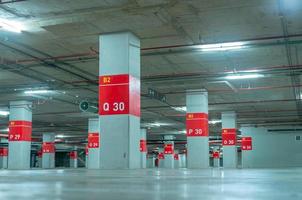 lege ondergrondse parkeerplaats. ondergrondse parkeergarage bij winkelcentrum of internationale luchthaven. overdekte parkeerplaats. parkeergarage onder betonvloer. interieur gebouw in de stad. foto