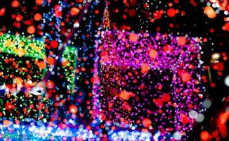 kerstmis en gelukkig nieuwjaar decoratie licht. rood, neon groen, blauw, roze bokeh achtergrond met prachtig patroon. intreepupil kerstlicht in de nacht van feest. kerst vakantie bokeh achtergrond. foto