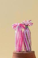 roze en wit gestreepte zakjes in doorzichtige flessen. foto