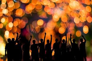 siluette mannen steken hun hand op met oranje bokeh. foto