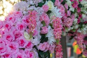 veel kunstmatige boeketten van roze bloemen met bokeh-verlichting. foto