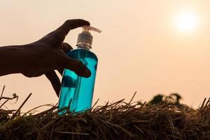 vinger op een fles gel met achtergrondverlichting op stro. foto