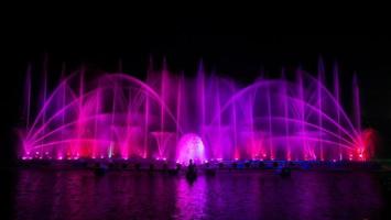 de kleurrijke fontein dansen ter viering van het jaar met donkere nachtelijke hemelachtergrond. foto
