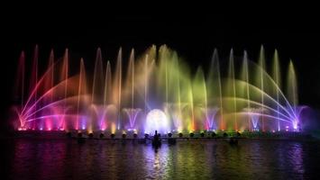 de kleurrijke fontein dansen ter viering van het jaar met donkere nachtelijke hemelachtergrond. foto