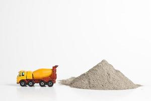 miniatuur betonwagen naast stapel cementpoeder foto
