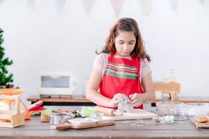 Europese meisjes bereiden gereedschappen en ingrediënten voor het maken van peperkoek tijdens kerst- en nieuwjaarsvieringen foto