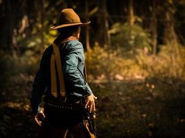 de senior cowboy staat zich voor te bereiden op een vuurgevecht tegen tegenstanders in de verboden westerse landen foto