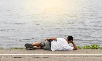 mannen liggen op straat in de buurt van watergolven. foto