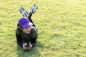 vrouw met een pet, rustend op een grasveld. foto