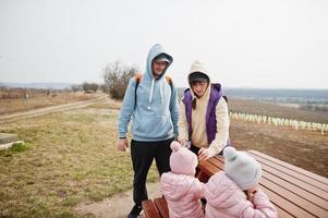 gezin met kinderen zitten aan houten tafel tegen wijngaard. foto