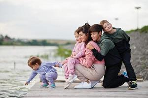 moeder liefde. moeder met vier kinderen buiten op de pier. sport grote familie vrije tijd buitenshuis doorbrengen. foto