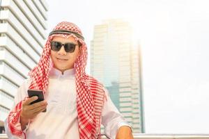 jonge Arabische zakenman uit het Midden-Oosten met behulp van mobiele smartphone wazige achtergrond foto