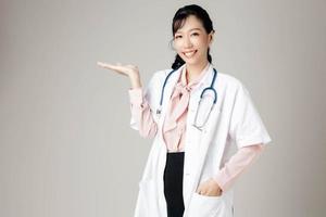 portret van een aantrekkelijke jonge vrouwelijke arts in witte jas. foto