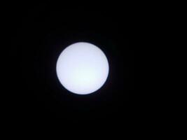 de zon bekeken door een zonnefilter in een telescoop foto