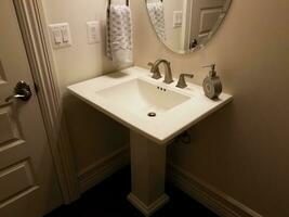 witte platte badkamer wastafel met deur en spiegel foto