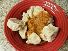 Aziatische dumplings en rode saus in kom foto