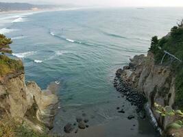 klif en oceaanwater met golven en rotsen in newport, oregon foto