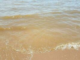 zand met golven en rotsen foto