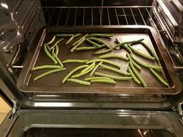 gekruide sperziebonen op bakplaat in oven foto