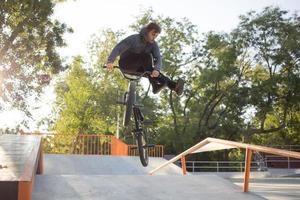 bmx-rijderstraining en trucs doen op straatplein, fietsstuntrijder in cocncrete skatepark foto