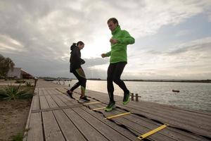 groep jongeren die buiten traint, hardlopersoefeningen, zee- of rivierachtergrond foto