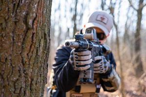 man van particulier militair bedrijf met geweer in het bos foto