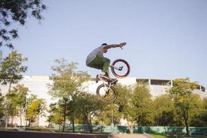 bmx-rijderstraining en trucs doen op straatplein, fietsstuntrijder in cocncrete skatepark foto