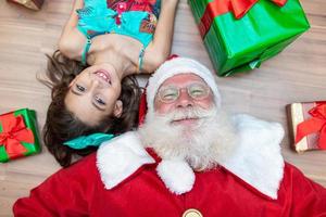 de kerstman levert een geschenkdoos aan een klein meisje. kerstavond, levering van geschenken. foto