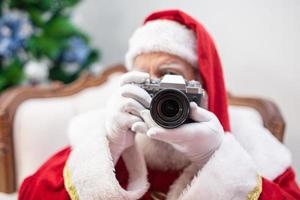 kerstman met vintage camera. portret geïsoleerd op gele achtergrond. foto