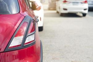 achterkant of rode auto stoppen en in de rij staan op asfaltwegen. zonovergoten buitenparkeerplaats. foto