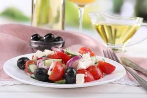 Griekse salade geserveerd in plaat met wijn op tafel foto