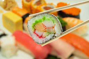 sushi in eetstokjes met onduidelijk beeldsushi op een plaatachtergrond foto