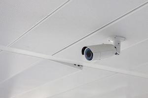 moderne beveiligingscamera met kantoor- of huisachtergrond, cctv om op te nemen en eigendomsbescherming voor parkeerplaats foto