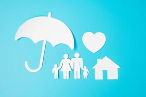 paraplu cover familie, huis en hart vorm papier op blauwe achtergrond. internationale dag van gezinnen, zorg, welzijn en verzekeringen foto