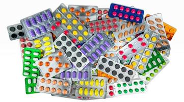 veel van tablet pillen geïsoleerd op een witte achtergrond. gele, paarse, zwarte, oranje, roze, groene tabletpillen in blisterverpakking. pijnstiller medicijn. geneesmiddel tegen migrainehoofdpijn. farmaceutische industrie. foto
