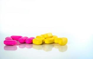 gele en roze ovale tabletpillen met schaduwen op witte achtergrond met kopie ruimte voor tekst. milde tot matige pijnbestrijding. pijnstillend medicijn. ibuprofen caplets pillen. foto