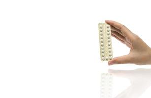 Aziatische volwassen vrouw hand met pack van anticonceptiepillen geïsoleerd op een witte achtergrond met uitknippad. gezinsplanning kiezen met het concept van anticonceptiepillen foto