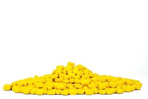 stapel gele ovaal-rechthoekige vorm tablet pillen geïsoleerd op een witte achtergrond met kopie ruimte. geneesmiddel voor verlichting van pijn en migrainehoofdpijn. farmaceutische industrie. wereldwijd zorgconcept. foto