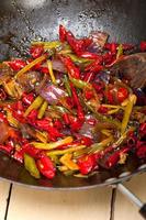 gebakken chili peper en groente op een wok pan